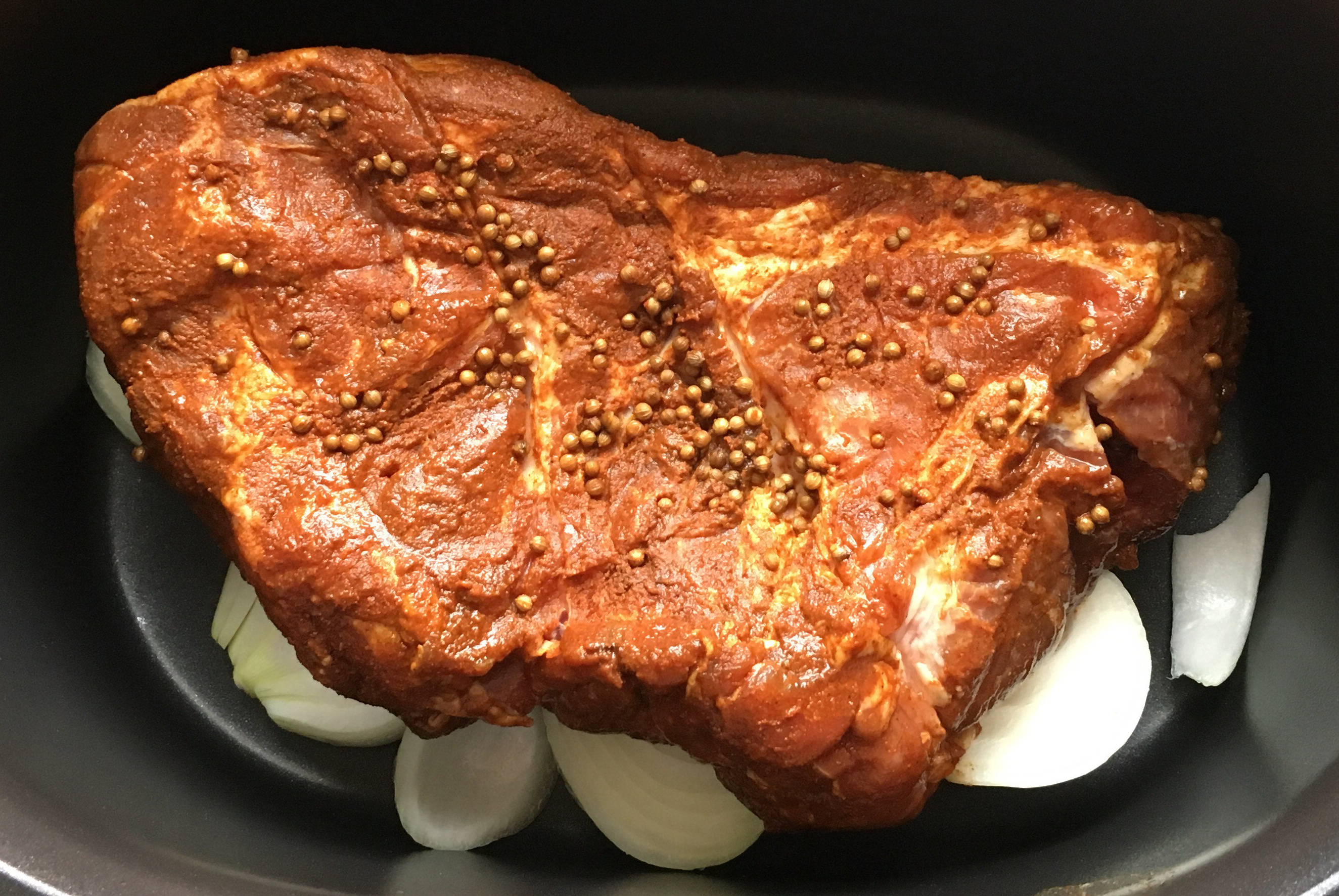 BBQ dry rubbed pork shoulder over a bed of onions
