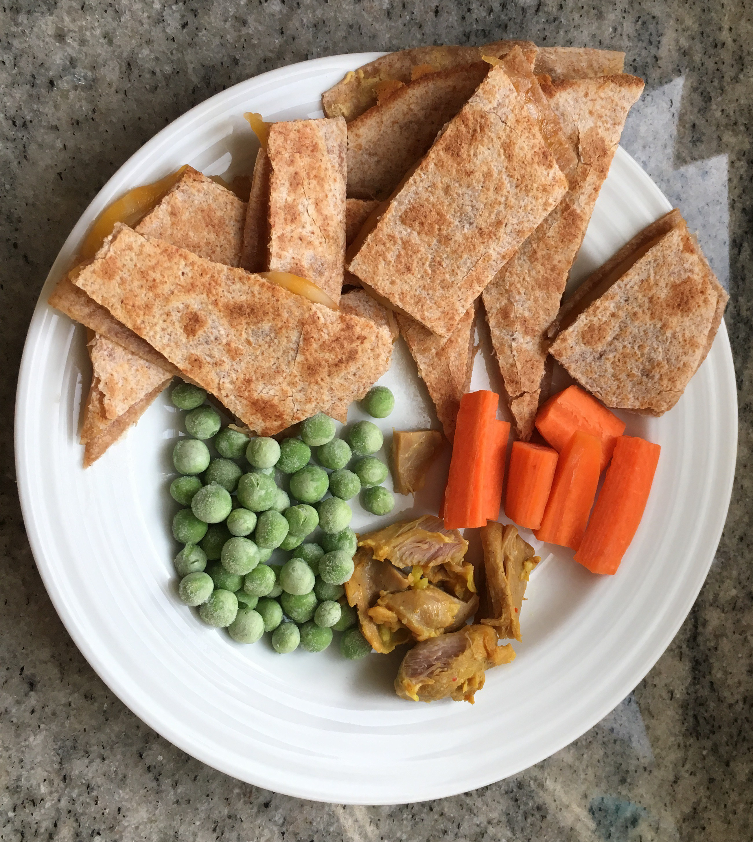 Kids quesadilla with chicken and veggies on the side.