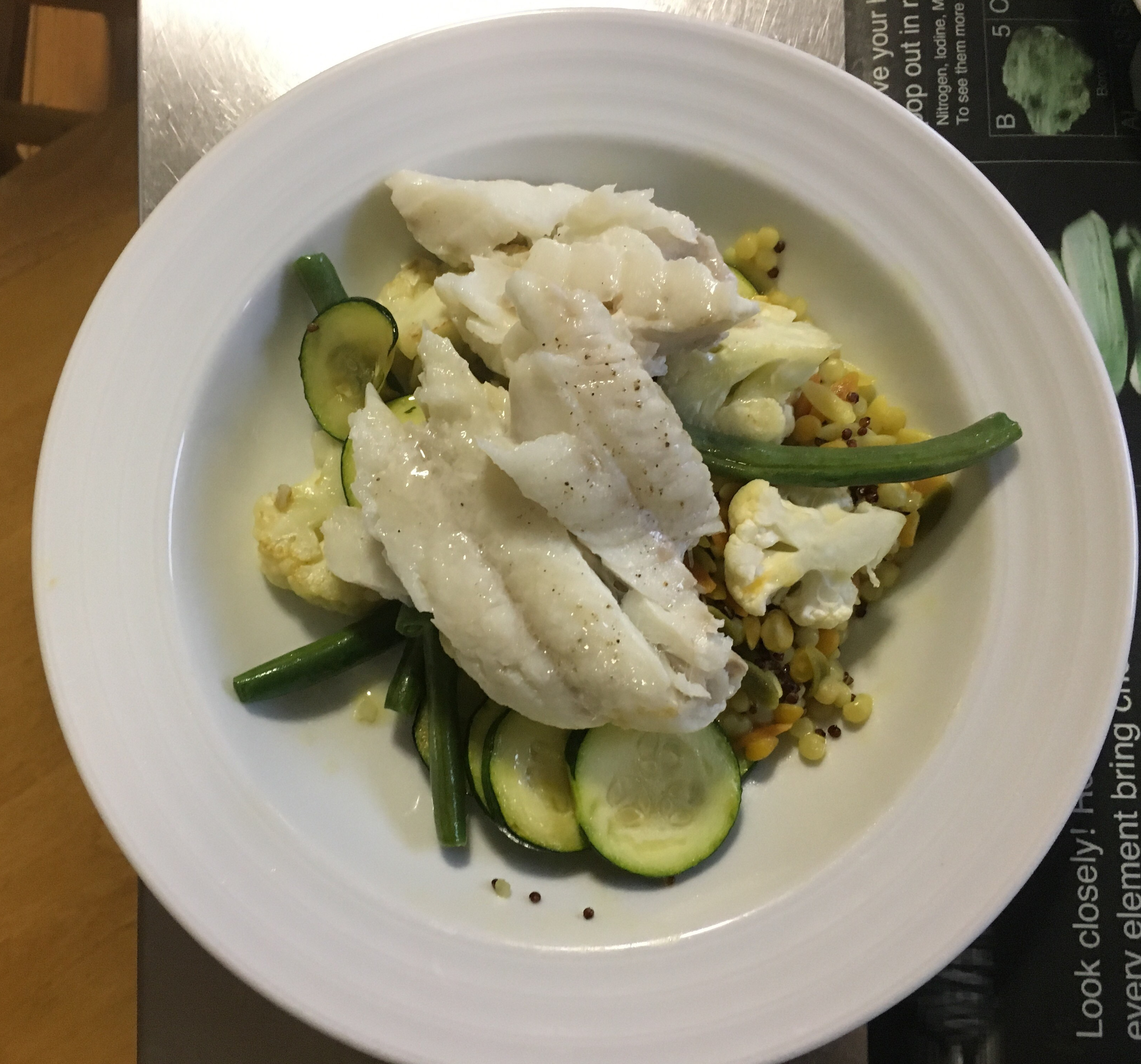 Braised fish over cous cos, beans, cauliflower & zucchini