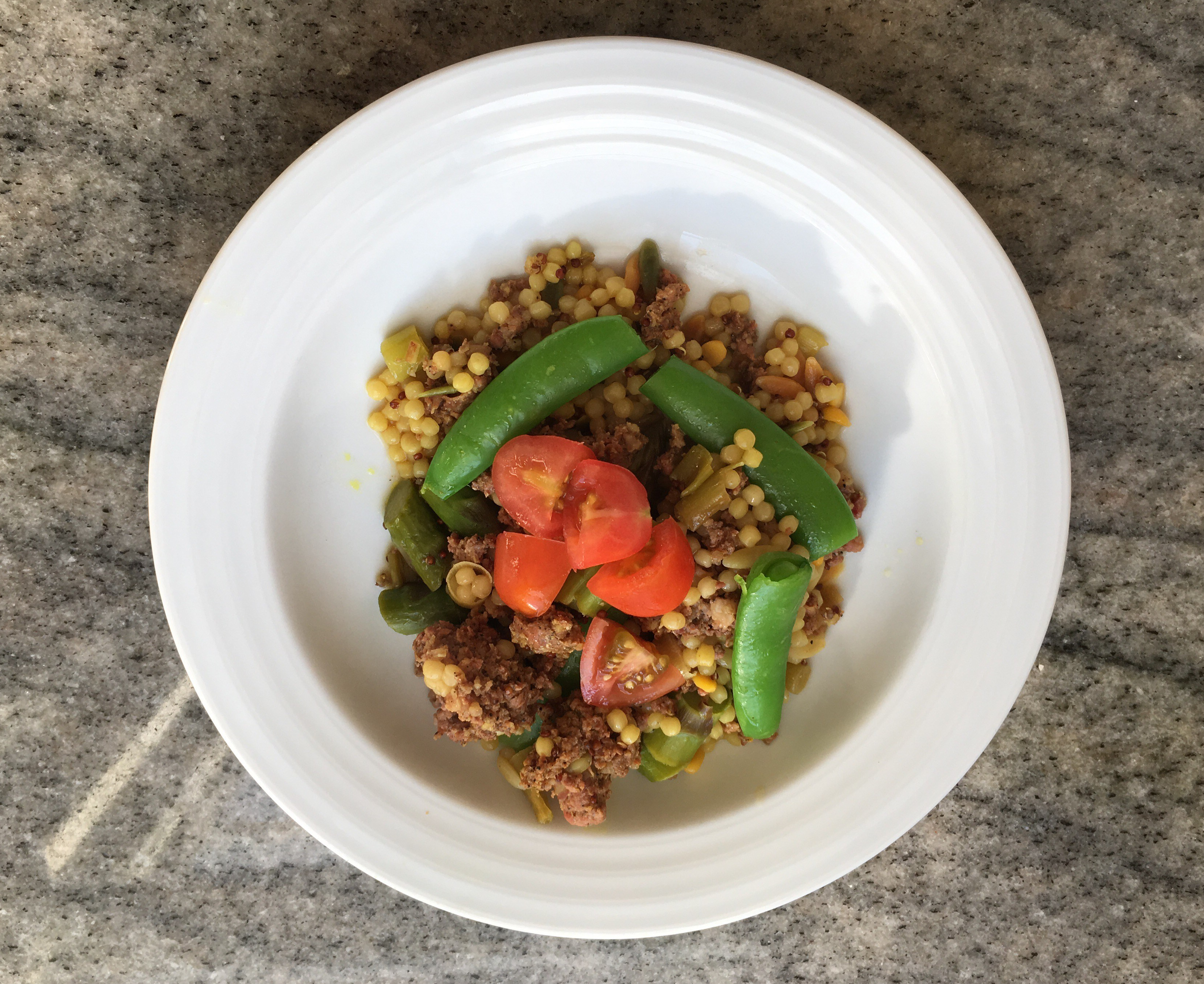 Cous cous with sausage, asparagus, sugar snap peas & topped with grape tomatoes.